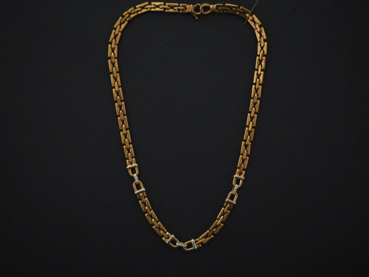 	Collier articulé deux tons d’or, maille plate. Les motifs du centre a