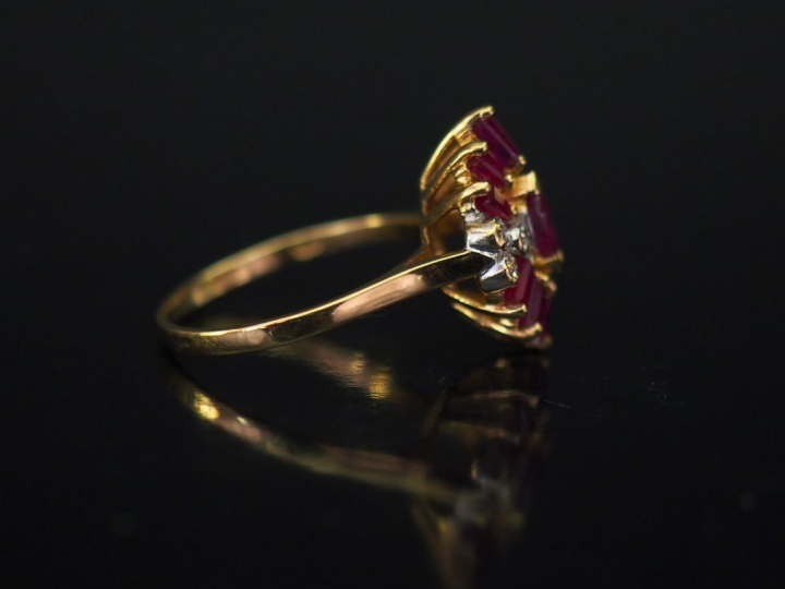 Bague en or jaune de forme stylisée, sertie de rubis calibrés et petit