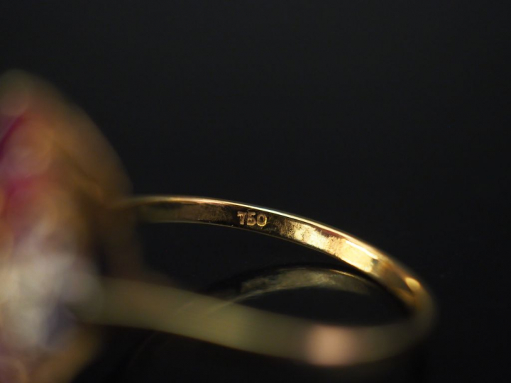 Bague en or jaune de forme stylisée, sertie de rubis calibrés et petit