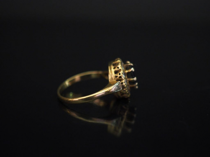 	Bague de forme marguerite en or jaune, sertie en son centre d’un saph