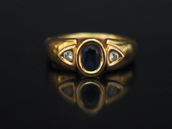 Bague en or jaune, sertie en son centre d'un saphir épaulé de deux pet