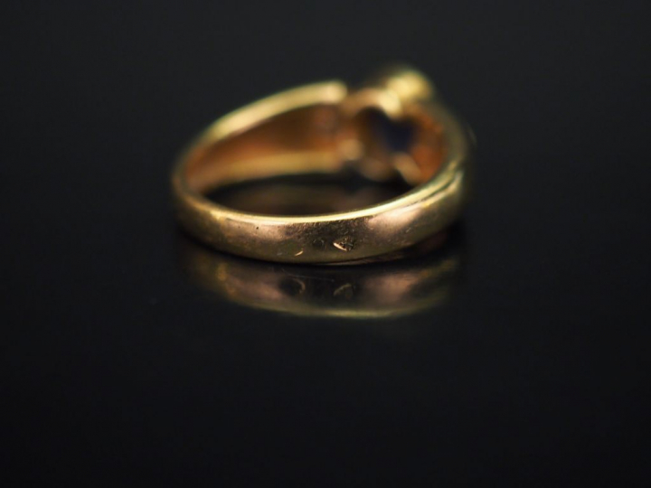 Bague en or jaune, sertie en son centre d'un saphir épaulé de deux pet