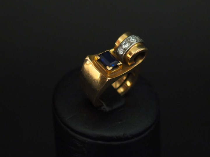 Bague tank en or jaune de forme stylisée, sertie d'une pierre bleue et
