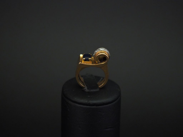 Bague tank en or jaune de forme stylisée, sertie d'une pierre bleue et