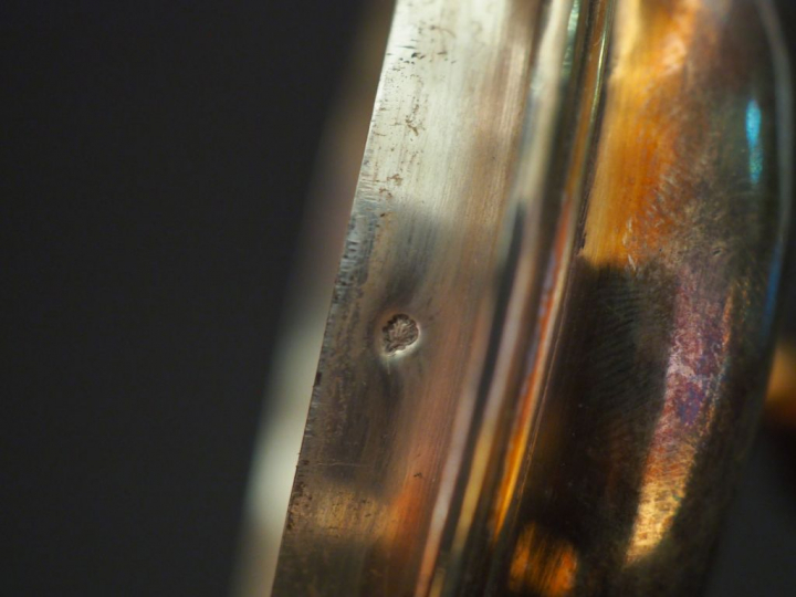 Verseuse tripode en argent lisse, agrémentée de filets.  Bec verseur c