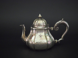 Vente aux enchères Petite théière à fond plat en argent étranger, à décor gravé d'entrela