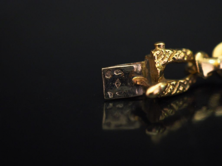 Bracelet articulé en or jaune, orné de cinq pendeloques :  - une pende