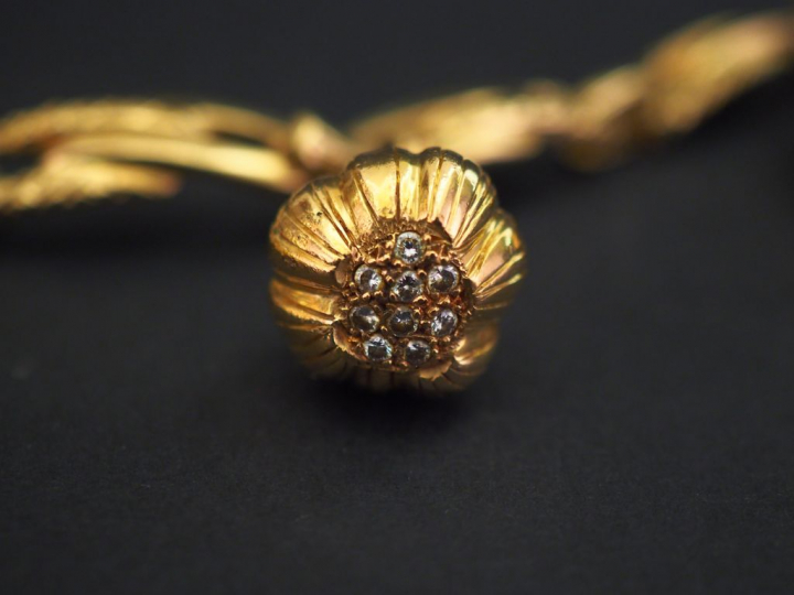 Bracelet articulé en or jaune, orné de cinq pendeloques :  - une pende