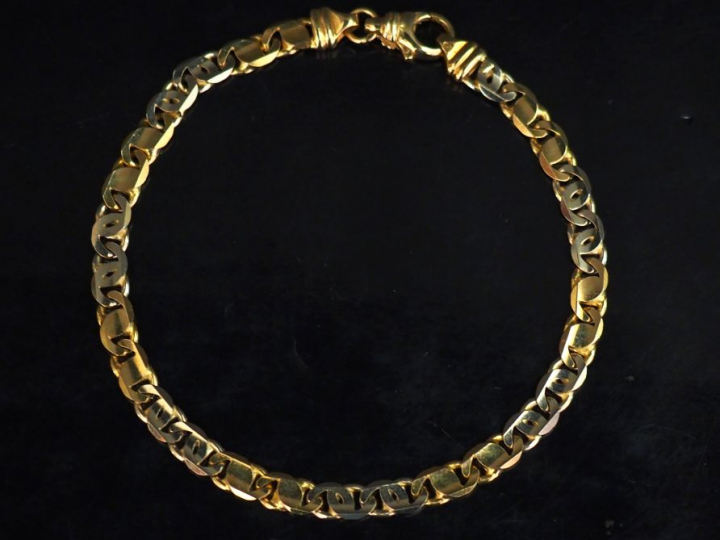 Bracelet souple deux tons d'or, maille plate ajourée.  Long. 21,5 cm P