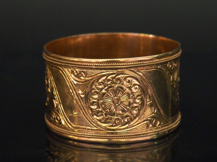 Bracelet manchette en or jaune, à décor gravé de rosaces.  Diam. 6,7 c