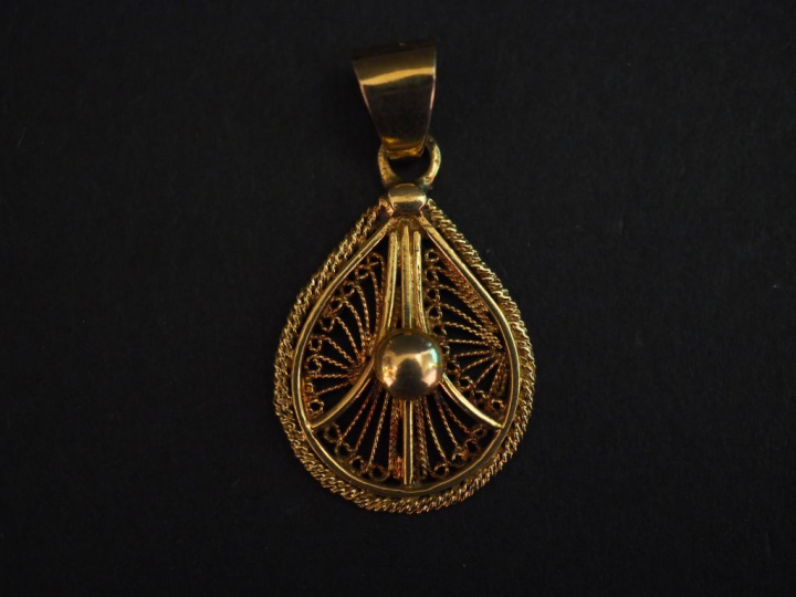 Pendentif en forme de goutte en or jaune, à décor ajouré et filigrané.