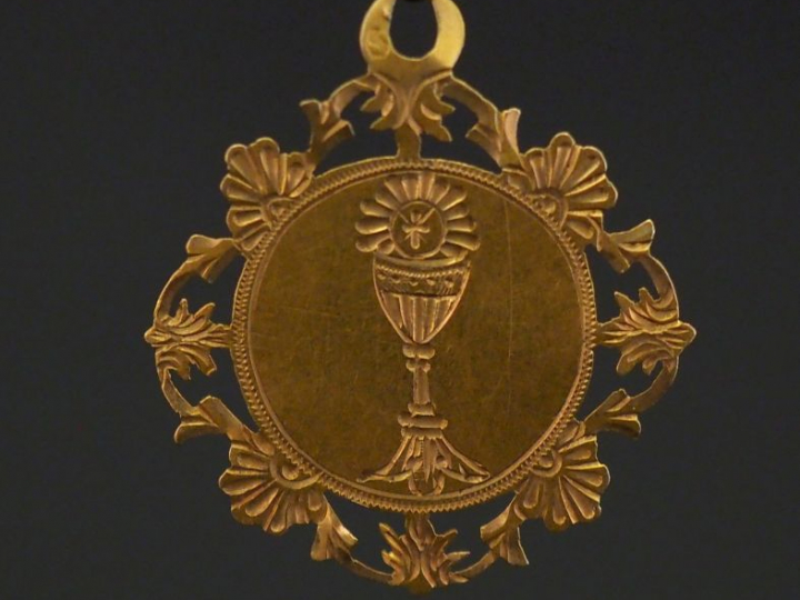Médaille religieuse de forme polylobée en or jaune, à décor d'un calic