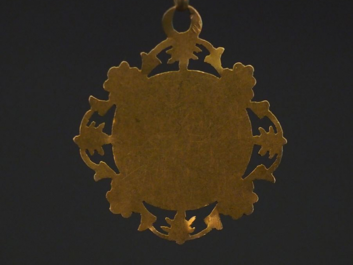 Médaille religieuse de forme polylobée en or jaune, à décor d'un calic