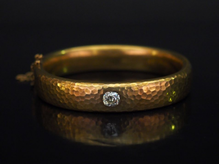 Bracelet jonc en or jaune martelé, serti en son centre d'un diamant ta