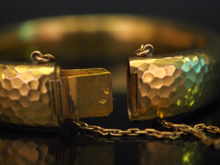 Bracelet jonc en or jaune martelé, serti en son centre d'un diamant ta