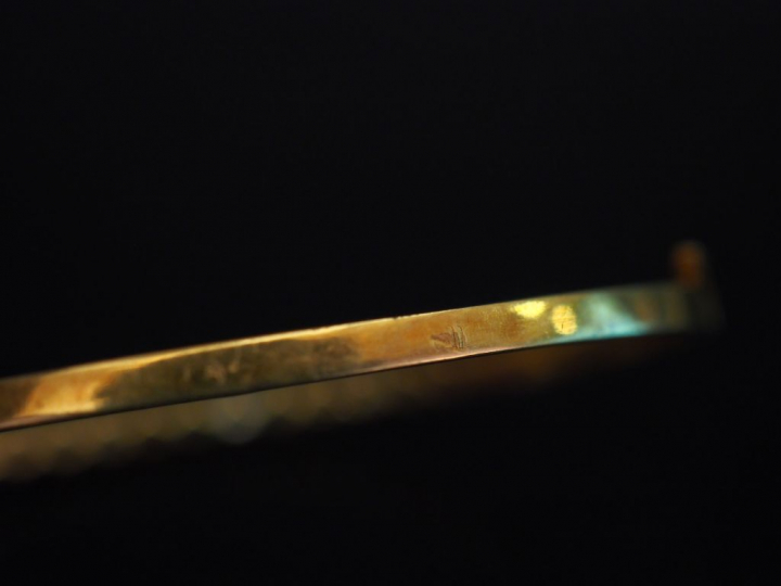 Bracelet jonc en or jaune, serti d'un rang de diamants et pierres de c