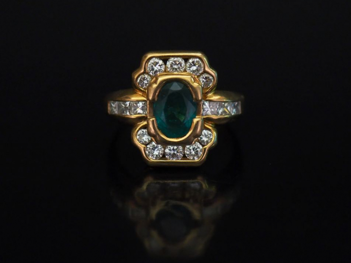 Bague en forme de nœud en or jaune, sertie en son centre d'une émeraud