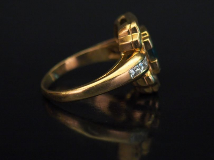 Bague en forme de nœud en or jaune, sertie en son centre d'une émeraud