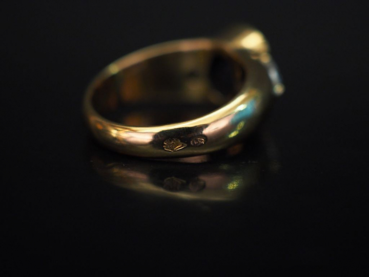 Bague jonc en or jaune, sertie en son centre d'un saphir épaulé de deu