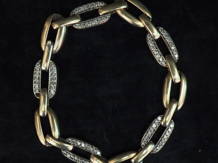 Bracelet articulé en or blanc, à décor de maillons sertis de deux lign