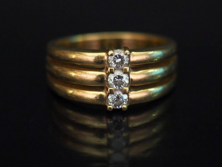 Bague en or jaune, sertie d'une ligne de trois petits diamants de 0,09