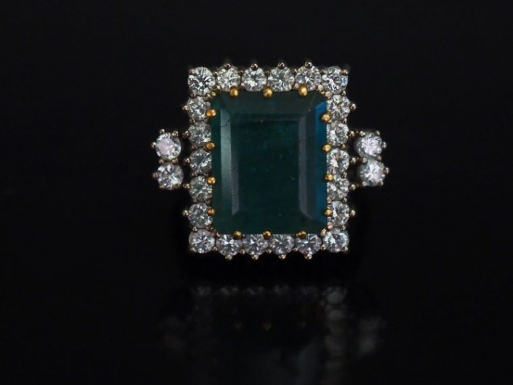 Bague en or blanc, sertie en son centre d'une émeraude entourée d'une 