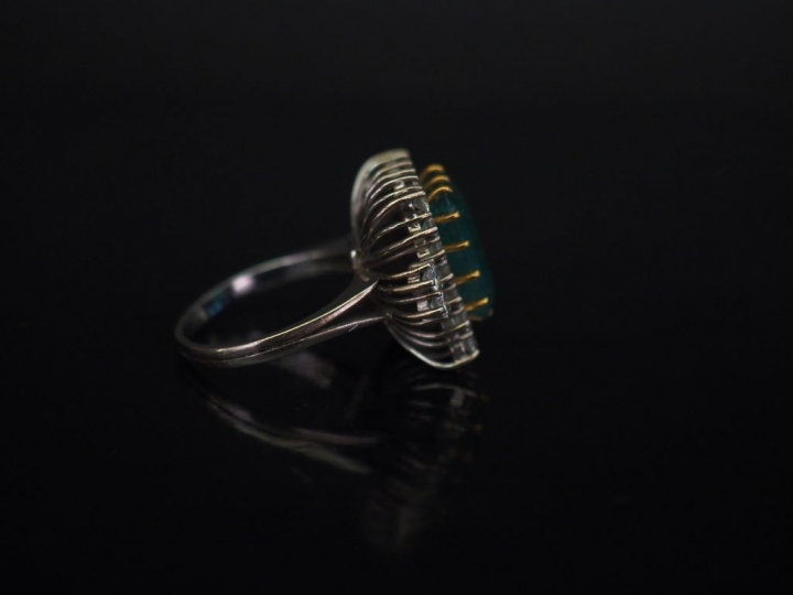 Bague en or blanc, sertie en son centre d'une émeraude entourée d'une 
