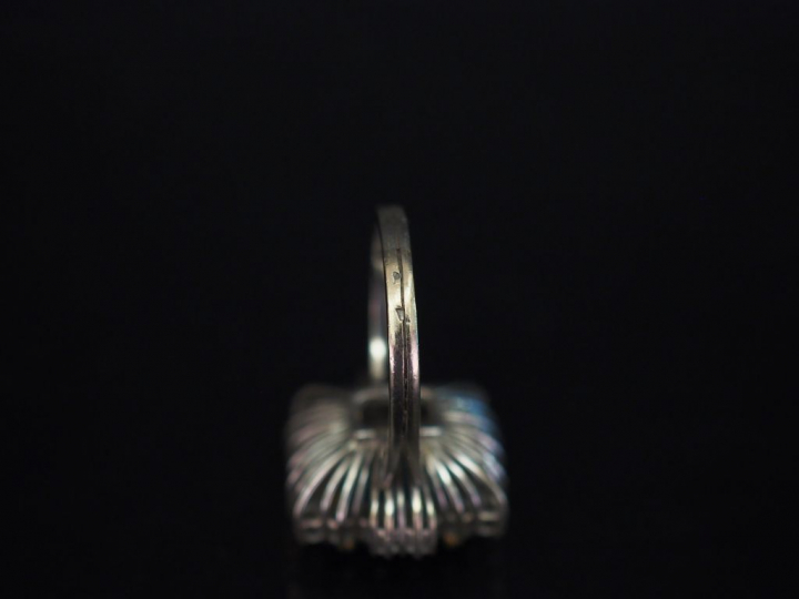 Bague en or blanc, sertie en son centre d'une émeraude entourée d'une 