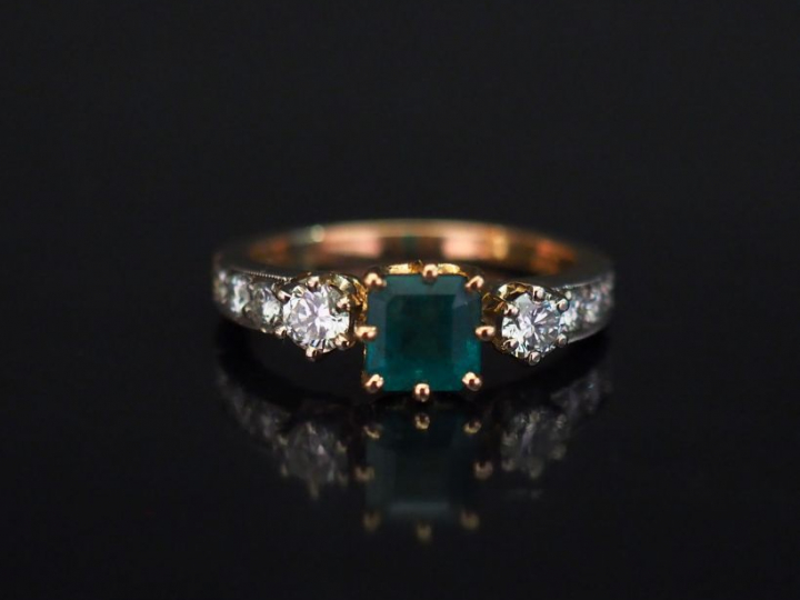 Bague jonc en or jaune, sertie en son centre d'une émeraude épaulée de