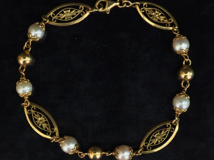 Bracelet articulé en or jaune, composé de maillons ovales ajourés et f