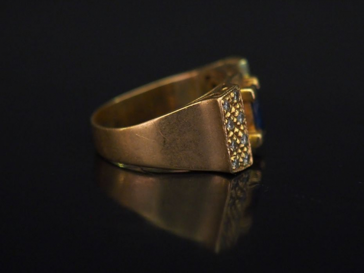 Bague tank en or jaune, sertie en son centre d'une pierre bleue et de 