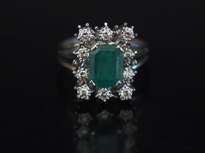 Bague en or blanc, sertie en son centre d'une émeraude entourée de dix