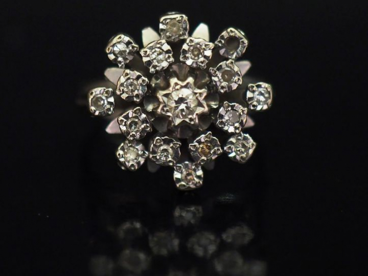 Bague en or blanc en forme de fleur épanouie, sertie d'un diamant cent