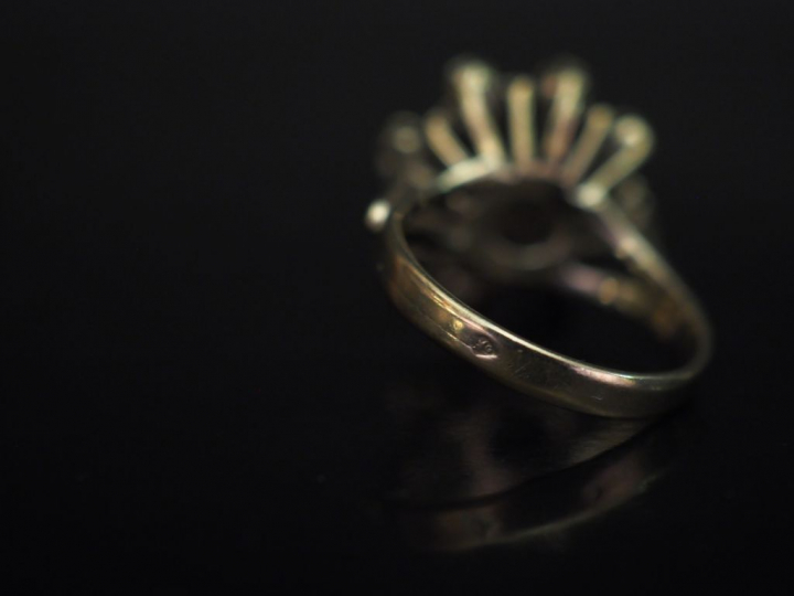 Bague en or blanc en forme de fleur épanouie, sertie d'un diamant cent