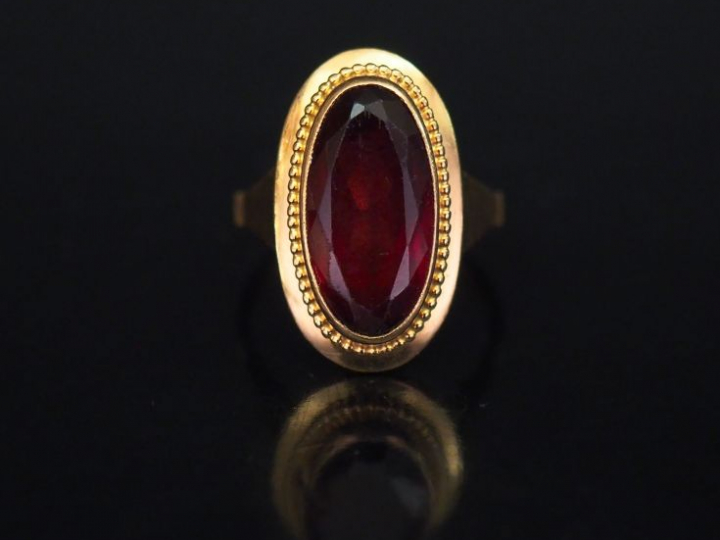 Bague ovale en or jaune, sertie en son centre d'un grenat (?). TDD. 50