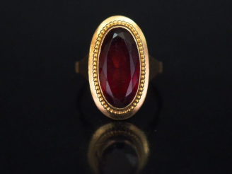 Vente aux enchères Bague ovale en or jaune, sertie en son centre d'un grenat (?). TDD. 50