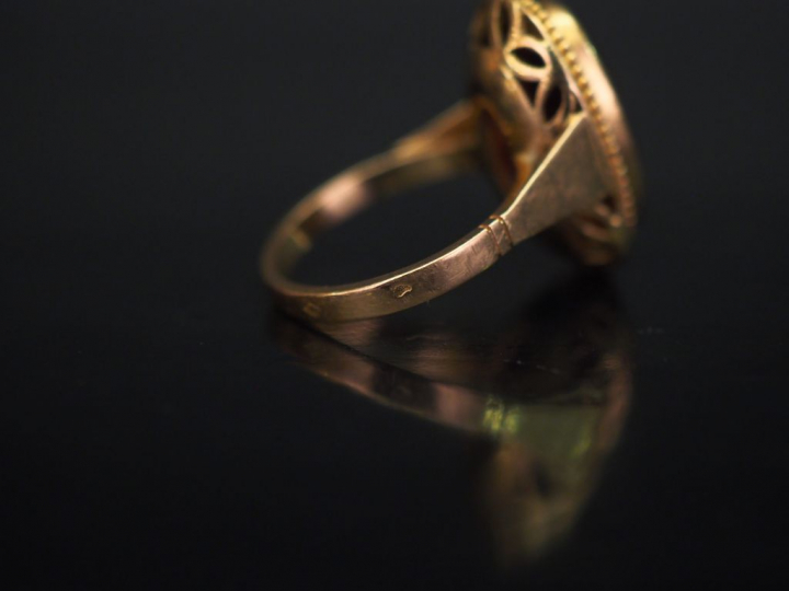 Bague ovale en or jaune, sertie en son centre d'un grenat (?). TDD. 50