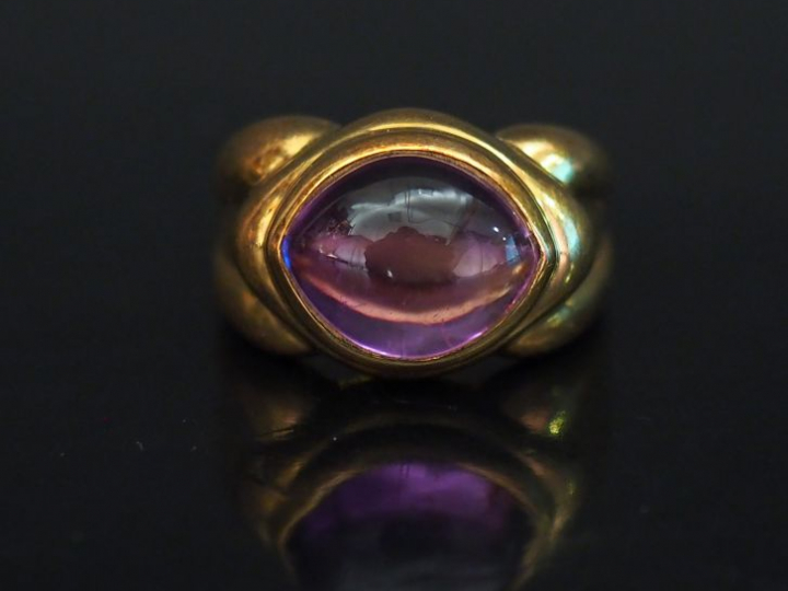 Bague dôme en or jaune, sertie en son centre d'une pierre mauve (améth