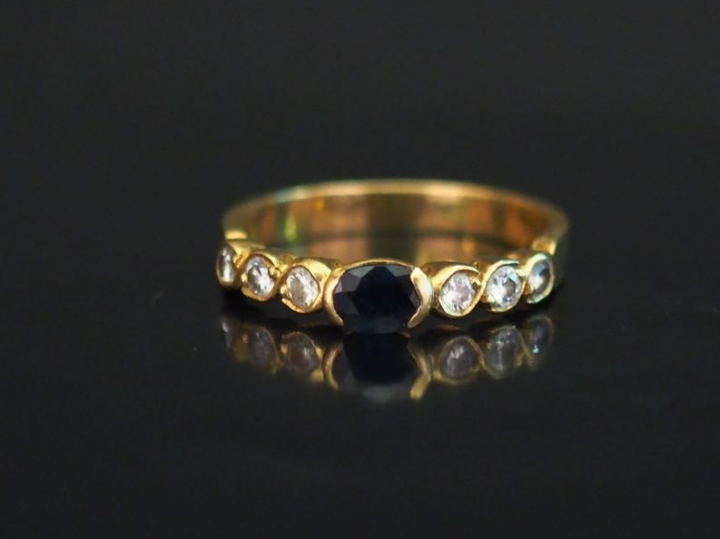 Petite bague en or jaune, sertie en son centre d'une pierre bleue épau