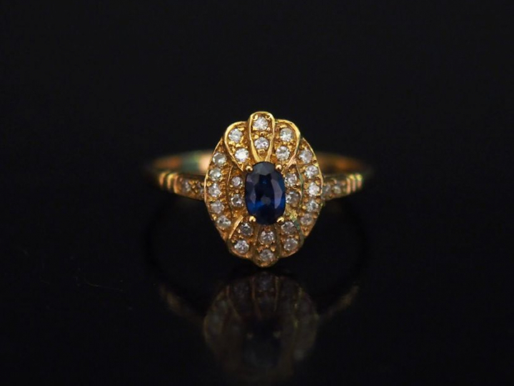 Petite bague en or jaune, sertie en son centre d'un saphir entouré d'u