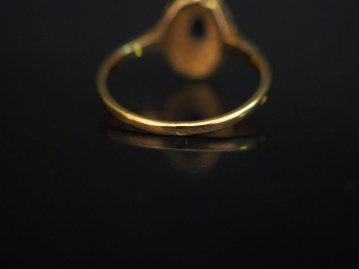 Petite bague en or jaune, sertie en son centre d'un saphir entouré d'u