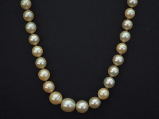 Vente aux enchères Collier de perles blanches disposées en chute.  Fermoir de forme cylin