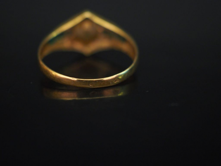 Bague en or jaune, sertie en son centre d'une perle épaulée de pierres