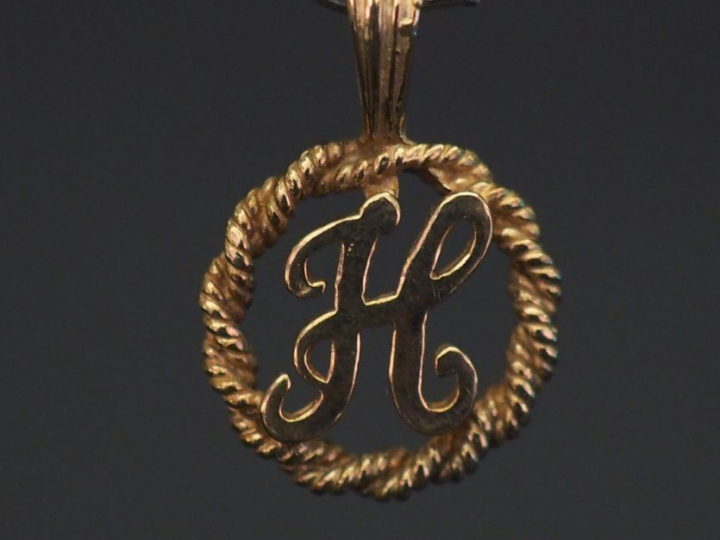 Pendentif ajouré en or jaune 9k, à décor de la lettre "H". Diam. 1,4 c