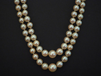 Vente aux enchères Collier de perles double rangs disposées en chute.  Fermoir en or jaun