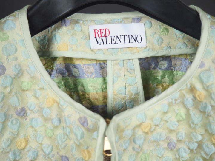 RED VALENTINO  Veste courte verte, à décor de fleurs gaufrées. Fermetu