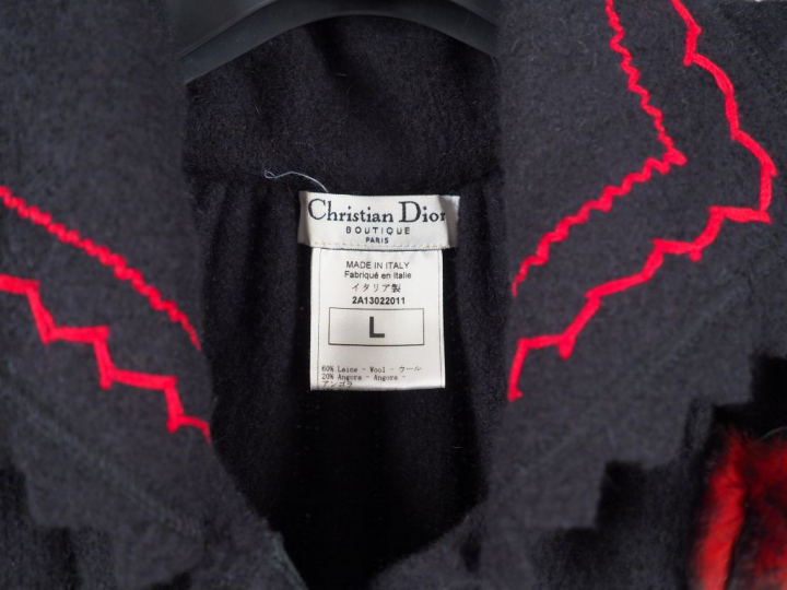CHRISTIAN DIOR Manteau noir, à décor de flocons rouges aux manches et 