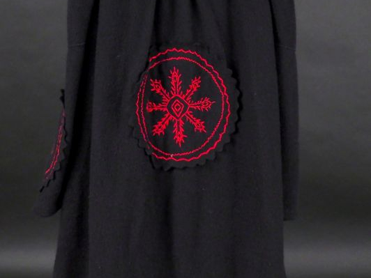 CHRISTIAN DIOR Manteau noir, à décor de flocons rouges aux manches et 