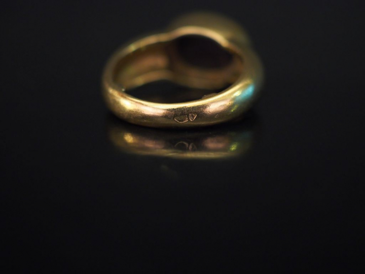 Bague jonc en or jaune, sertie en son centre d'une pierre dure en cabo