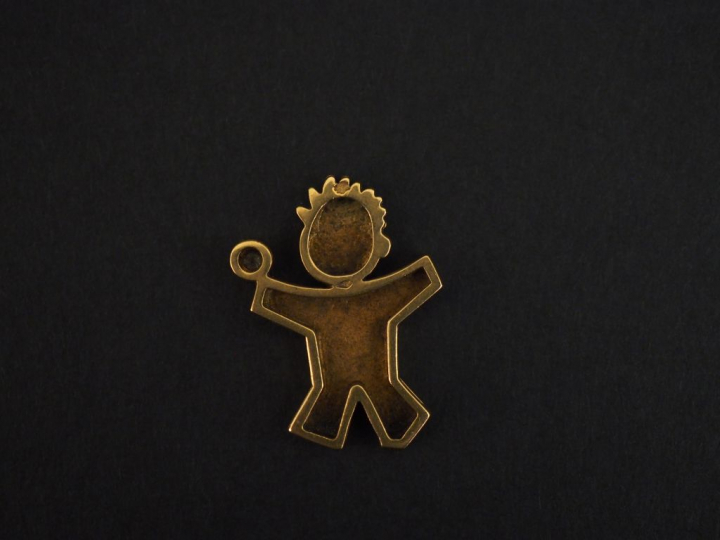 Pendentif en or jaune, en forme de bonhomme tenant dans sa main un pet
